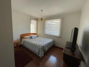 a bedroom with a bed and a flat screen tv at Hermosa casa Hostal de Miguel in Los Ángeles
