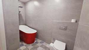 a bathroom with a toilet and a red trash can at Elia Hotel Alaçatı in Çeşme +45 photos