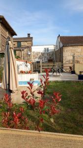 a garden with an umbrella and a pool at Casa da Eiriña in Amés