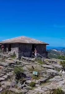 une femme debout à l'entrée d'un bâtiment sur une montagne dans l'établissement Bangalô de Pedras, à São Thomé das Letras 32 autres photos