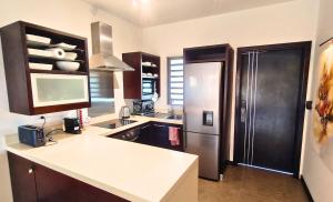 a kitchen with a refrigerator and a counter top at Tropical Elegance - Appartement in Grand Baie