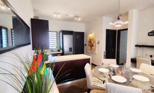 a dining room with a table and some chairs at Tropical Elegance - Appartement in Grand Baie +13 photos