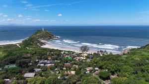 an aerial view of a beach with a lighthouse on a hill at Casa Oceano, Ilha do Mel in Paranaguá
