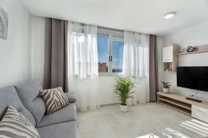 a living room with a couch and a television at Apartamento Iris in Igueste