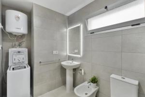 a white bathroom with a sink and a toilet at Apartamento Iris in Igueste