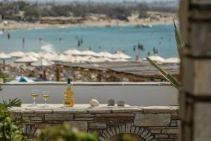 纳克索乔拉夏季时代一室公寓的一张桌子上放着两杯葡萄酒，可以欣赏到海滩景色。