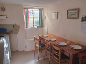 a dining room with a wooden table and chairs at Dolphin Cottage 50m from Shaldon Beach! in Shaldon
