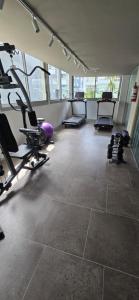 a gym with several treadmills and chairs in a room at Sudestada Apartamentos Turisticos in Punta del Este