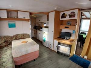 a small room with a kitchen and a caravan at Camping de la cigogne in Beaugeay