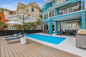 a house with a swimming pool and an umbrella at 7 Singleton Beach Place- Oceanfront, Private Pool, Renovated, FREE Activities Included in Hilton Head Island