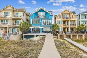a row of houses on the beach with a boardwalk at 7 Singleton Beach Place- Oceanfront, Private Pool, Renovated, FREE Activities Included in Hilton Head Island