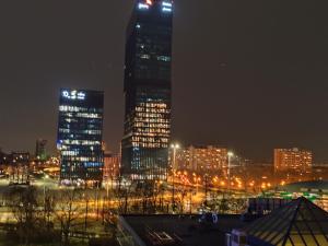 a city lit up at night with tall buildings at Black&Blue Apartament in Katowice