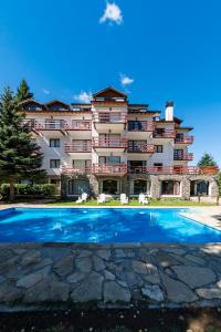 a hotel with a swimming pool in front of it at Apartur Catedral in San Carlos de Bariloche