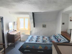 a bedroom with a bed and a dresser and a window at Dolphin Cottage 50m from Shaldon Beach! in Shaldon