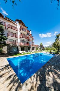 a hotel with a swimming pool in front of a building at Apartur Catedral in San Carlos de Bariloche