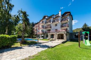 a large building with a playground in front of it at Apartur Catedral in San Carlos de Bariloche
