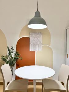 una sala da pranzo con tavolo e sedie bianchi di Meraki Stays - ETANA - SMDC Hope Residences a Trece Martires