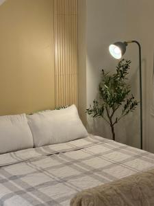 una camera con un letto con una lampada e una pianta di Meraki Stays - ETANA - SMDC Hope Residences a Trece Martires