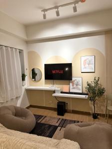 un soggiorno con TV e scrivania di Meraki Stays - ETANA - SMDC Hope Residences a Trece Martires