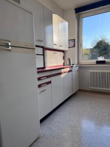 an empty kitchen with a refrigerator and a window at Monteurwohnung Osnabrück 3-Zimmer mit Balkon in Osnabrück