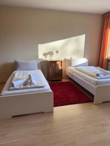 a bedroom with two beds and a red rug at Monteurwohnung Osnabrück 3-Zimmer mit Balkon in Osnabrück