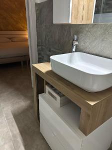 a bathroom with a white sink on a wooden counter at Altro Cielo in La Maddalena