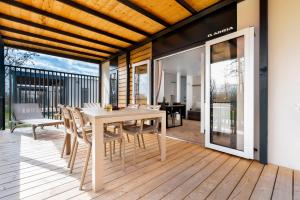 una sala da pranzo con tavolo e sedie su una terrazza di Mobile Homes Casapini in FKK Camping Solaris a Poreč (Parenzo)