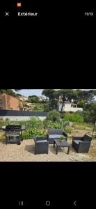 Sainte-Maxime appartement 45m avec jardin de 35m في سانت ماكسيم: صورة لأريكتين وطاولة ومقعد