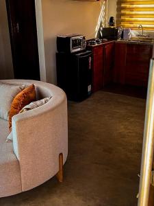 un salon avec un canapé et une cuisine dans l'établissement Bangalô de Pedras, à São Thomé das Letras