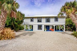 YbelにあるCharming Sanibel Island Home Minutes From The Beachのヤシの木が目の前に広がる白い家