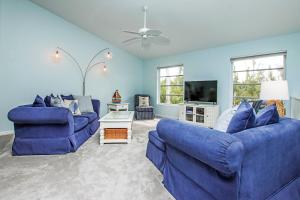 YbelにあるCharming Sanibel Island Home Minutes From The Beachの青いソファ2脚とテレビのあるリビングルーム