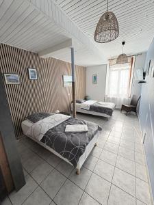 a bedroom with two beds and a chair in it at Horse House Calm and Nature near motorway and Basel in Kembs