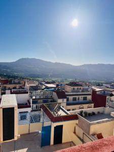 a view of a city with mountains in the background at Blue Pearl city in Chefchaouene