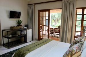 a bedroom with a bed and a sliding glass door at Karoo Escape 2 in Oudtshoorn