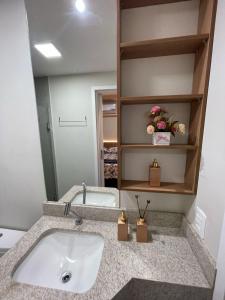 a bathroom with a sink and a mirror at Loft SUNSET - 8 ANDAR in Dourados +16 photos
