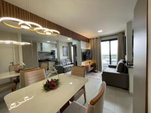 a dining room and living room with a table and chairs at Loft SUNSET - 8 ANDAR in Dourados