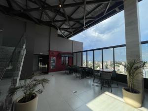 a large room with tables and chairs in a building at Loft SUNSET - 8 ANDAR in Dourados