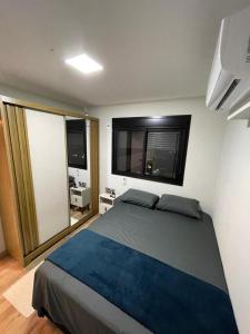 a bedroom with a large bed and two windows at Loft SUNSET - 8 ANDAR in Dourados