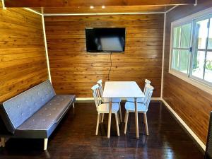 a dining room with a table and a couch and a tv at Las Luciérnagas del Delta 2 in Tigre