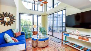 un salon avec un canapé bleu et une télévision à écran plat dans l'établissement Spacious 3BR Retreat On Sanibel Island - Steps To The Water, à Sanibel