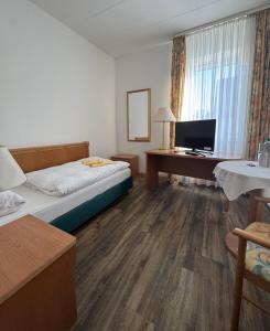 フュルステンフェルトブルックにあるHotel zum Unterwirtのベッドとパソコン付きの机がある寝室