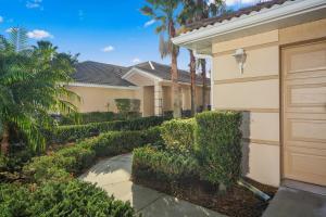 une maison avec des arbres et des buissons à côté d'une allée. dans l'établissement Golfer's paradise in resort style Heritage Harbour, à Bradenton