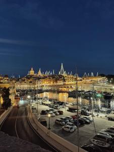 a city at night with cars parked in a parking lot at Żiffa Ta' Riħ - A Cosy Apartment in Senglea with Wi-Fi and Smart TV in Senglea
