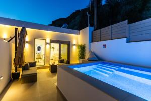 a villa with a swimming pool at night at BLU Faflagkos Bay Luxury Suites in Psari Forada