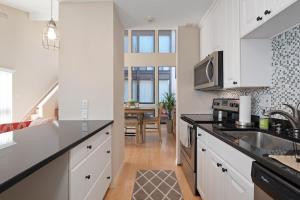 a kitchen with white cabinets and a counter top at Gorgeous Lido Key condo - 6 minute walk to beach in Sarasota