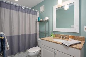 a bathroom with a sink and a toilet and a mirror at Gorgeous Lido Key condo - 6 minute walk to beach in Sarasota +11 photos