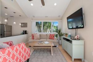 a living room with a couch and a flat screen tv at Gorgeous Lido Key condo - 6 minute walk to beach in Sarasota
