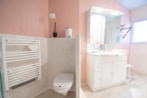 a pink bathroom with a toilet and a sink at Le Petit Moulin I Plage et terrasse in Crozon