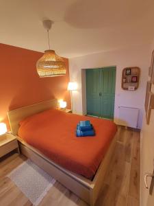 a bedroom with a large orange bed with blue sheets at La Maisonnette - Disneyland Paris in Chanteloup-en-Brie