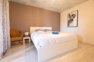 a bedroom with a white bed in a room at Le Petit Moulin I Plage et terrasse in Crozon